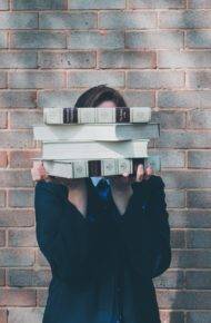 persona pila di libri